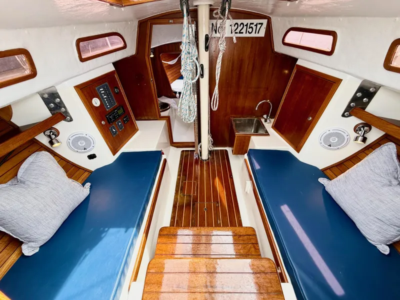 Slide: The Image of Interior of 2009 e Sailing Yachts e33, featuring wooden finishes and blue seating. - 19