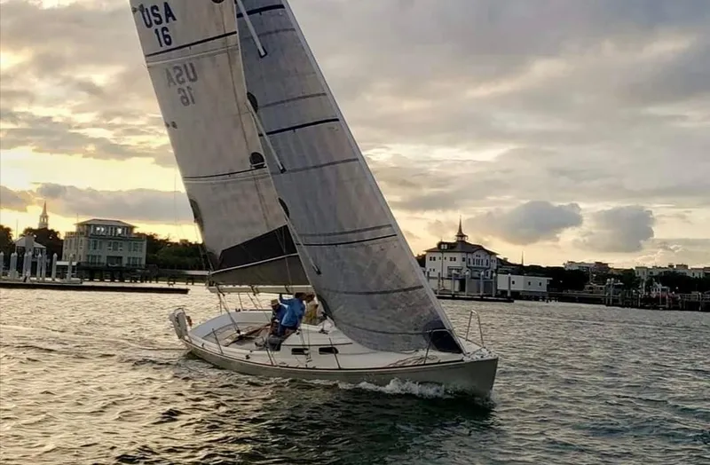 Slide: The Image of Sailing yacht e33 from 2009 gliding on water at sunset with scenic background. - 2