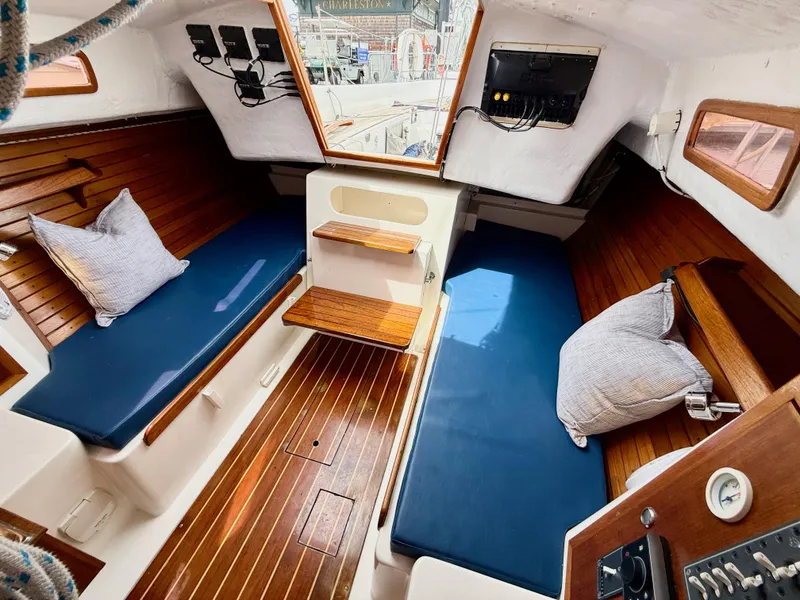 Slide: The Image of 2009 e Sailing Yachts e33 interior with wooden flooring, blue cushions, and nautical decor. - 20