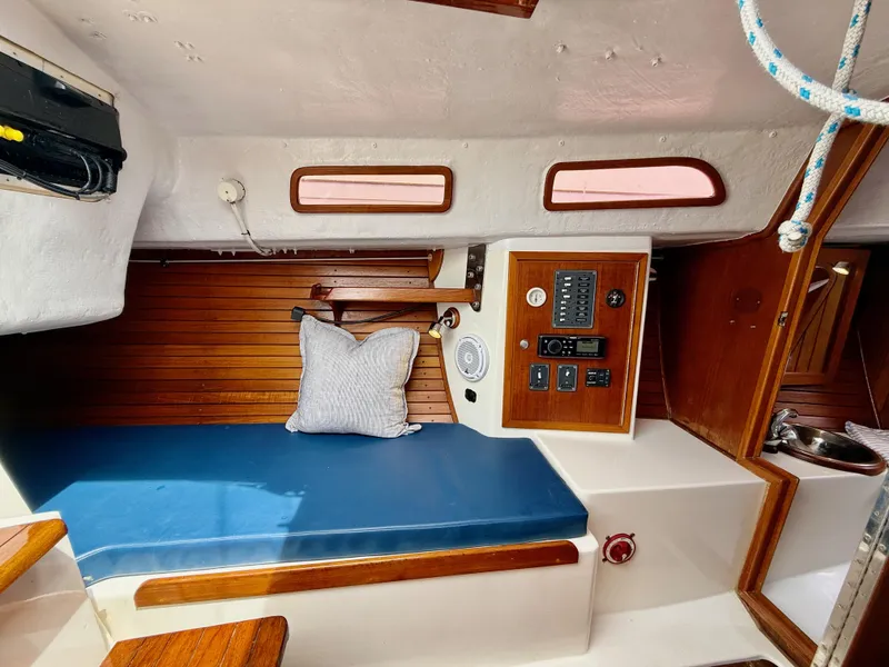 Slide: The Image of Interior of 2009 e Sailing Yachts e33, featuring a cozy cabin with blue seating. - 22