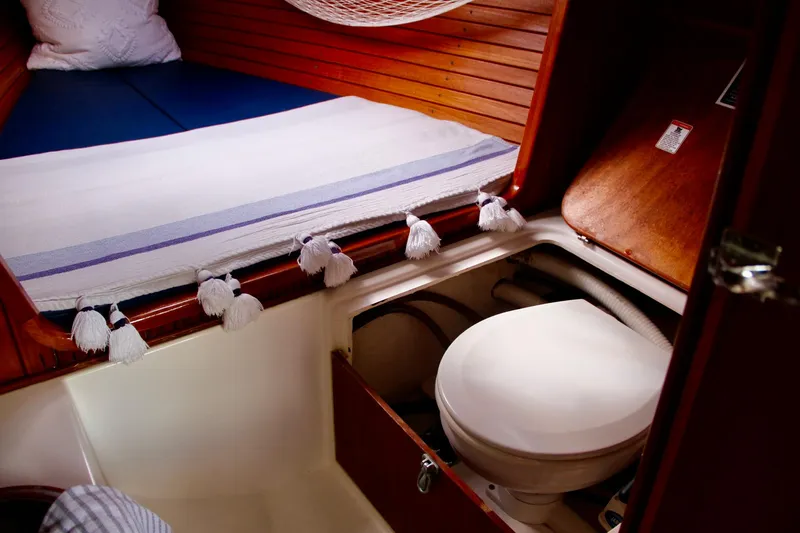 Slide: The Image of Interior of 2009 e Sailing Yachts e33, featuring a compact marine toilet and cozy sleeping area. - 28