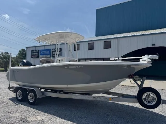 Slide: The Image of 2018 Tidewater 220 LXF boat on trailer, parked outside a large building. - 1