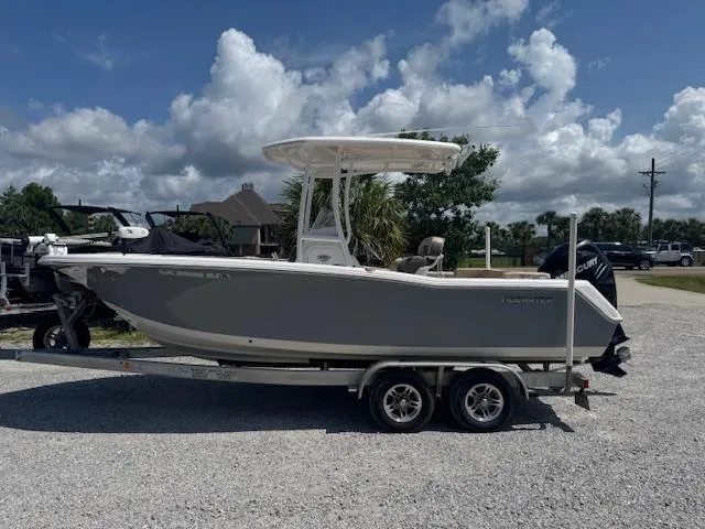 Slide: The Image of 2018 Tidewater 220 LXF boat on trailer, parked outdoors under a cloudy sky. - 6