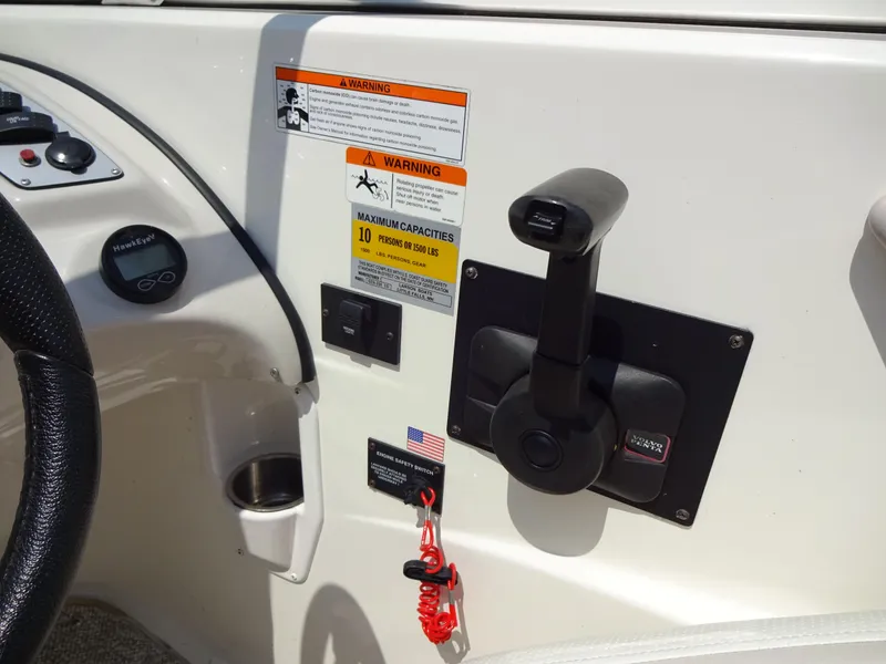 Slide: The Image of 2007 Larson 206 Senza boat dashboard with throttle control and warning labels. - 11