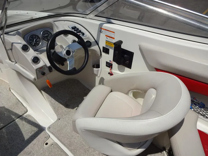 Slide: The Image of Interior of a 2007 Larson 206 Senza boat with steering wheel and controls. - 12