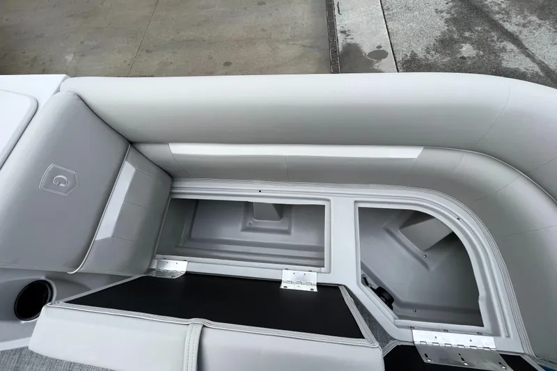 Slide: The Image of 2025 Godfrey Xperience Cruise boat interior with open storage compartments and cushioned seating. - 17