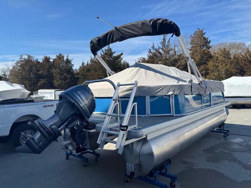 Slide: The Image of 2025 Godfrey Xperience Cruise pontoon boat with outboard motor, docked outdoors. - 4