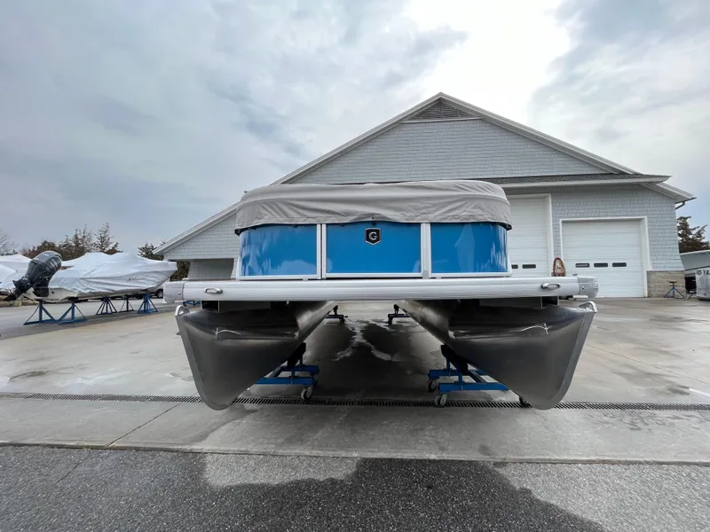 Slide: The Image of 2025 Godfrey Xperience Cruise pontoon boat parked in front of a garage. - 6