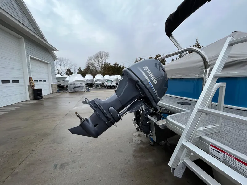 Slide: The Image of 2025 Godfrey Xperience Cruise boat with Yamaha outboard motor in a storage facility. - 9