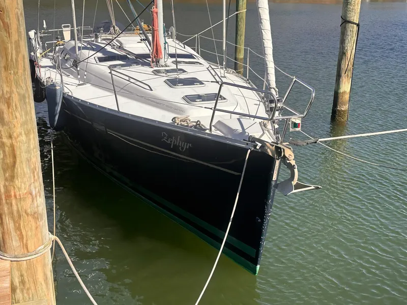 Slide: The Image of 2002 Beneteau 393 sailboat docked in calm waters, side view. - 2