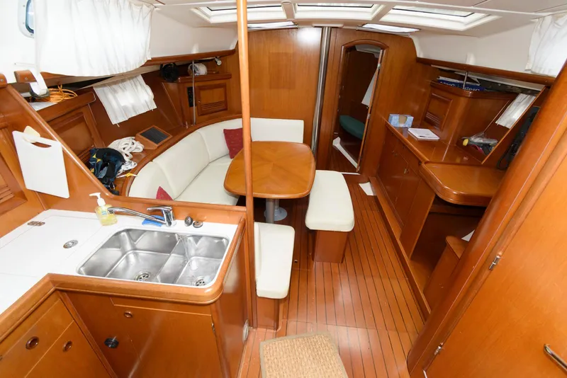 Slide: The Image of Interior of 2002 Beneteau 393 yacht with wood finish and cozy seating area. - 8