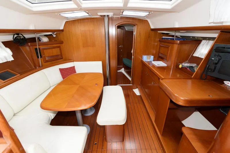 Slide: The Image of Interior of 2002 Beneteau 393 yacht with wooden furnishings and white seating. - 9