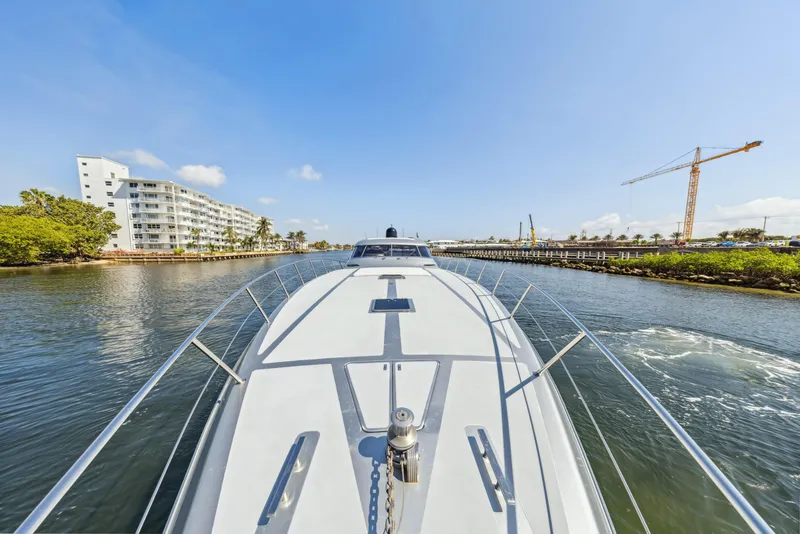 Slide: The Image of 2003 Baia PANTHER 80 yacht cruising in a scenic waterway with buildings and crane. - 22