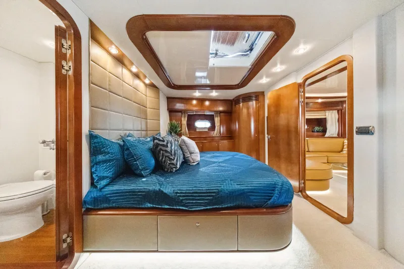 Slide: The Image of Luxurious 2003 Baia Panther 80 yacht bedroom with blue bedding and elegant wood accents. - 48