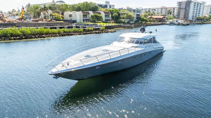 Slide: The Image of 2003 Baia Panther 80 yacht cruising on a calm waterway near a residential area. - 6