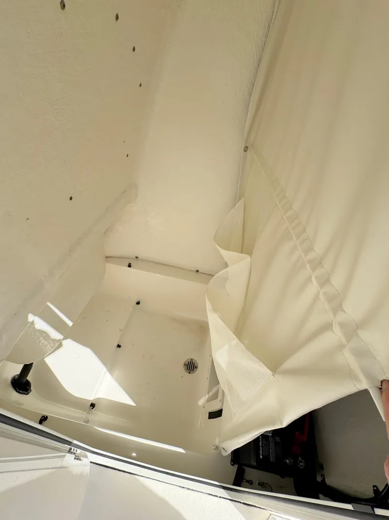 Slide: The Image of 2023 Key West 239 FS boat interior with white upholstery and storage area. - 13