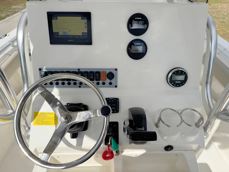 Slide: The Image of 2023 Key West 239 FS boat dashboard with steering wheel, gauges, and navigation display. - 17