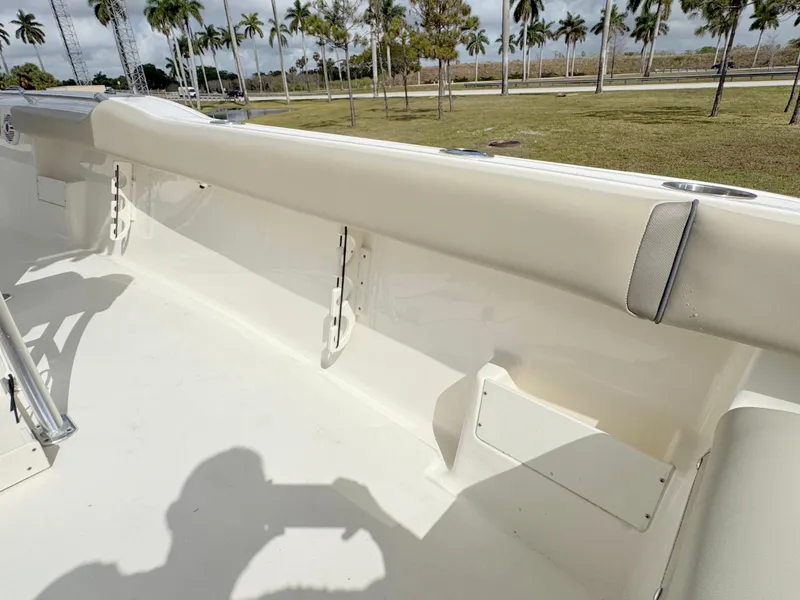 Slide: The Image of 2023 Key West 239 FS boat interior with beige seating and palm trees in the background. - 22