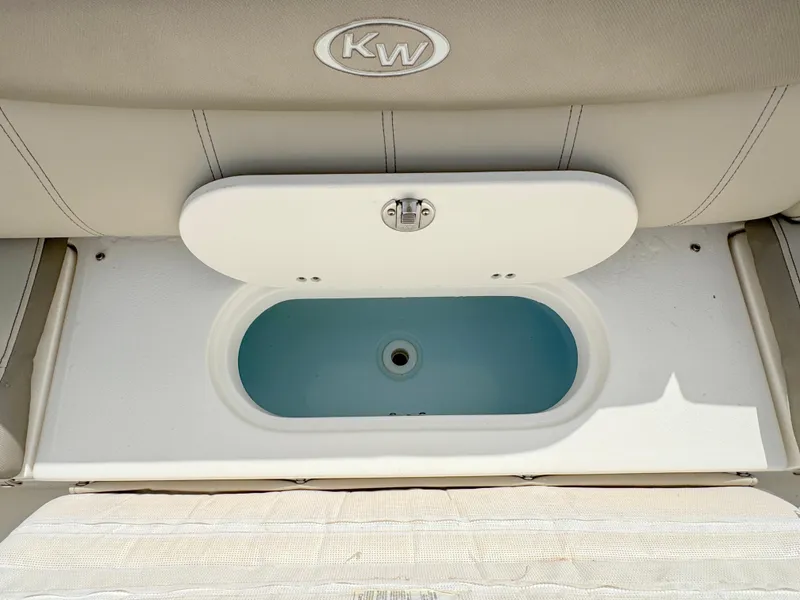 Slide: The Image of 2023 Key West 239 FS boat storage compartment with open lid, showcasing interior space. - 25