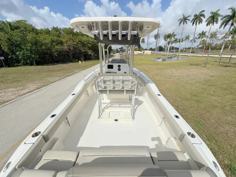 Slide: The Image of 2023 Key West 239 FS boat with spacious deck and seating, set against a tropical backdrop. - 26