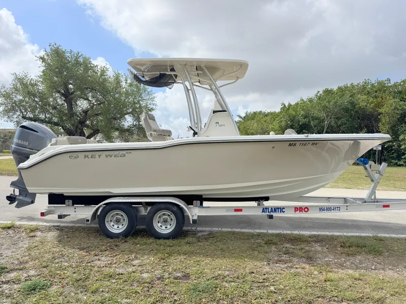 Slide: The Image of 2023 Key West 239 FS boat on trailer, side view, outdoors, cloudy sky. - 5