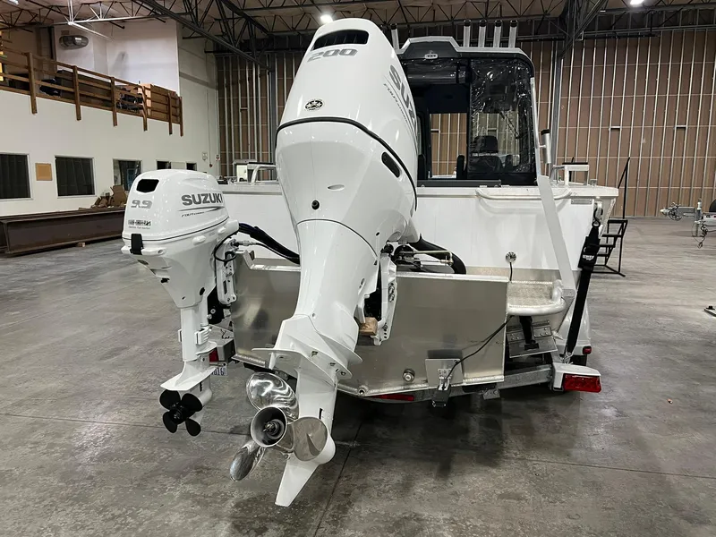 Slide: The Image of 2022 Hewescraft 210 Sea Runner ET HT boat with dual Suzuki outboard motors in a warehouse. - 8