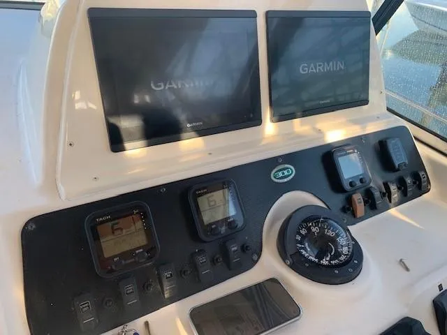 Slide: The Image of 2006 Grady-White Marlin 300 dashboard with Garmin navigation displays and controls. - 10
