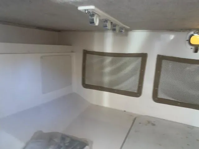 Slide: The Image of 2006 Grady-White Marlin 300 cabin interior with storage compartments and porthole. - 12