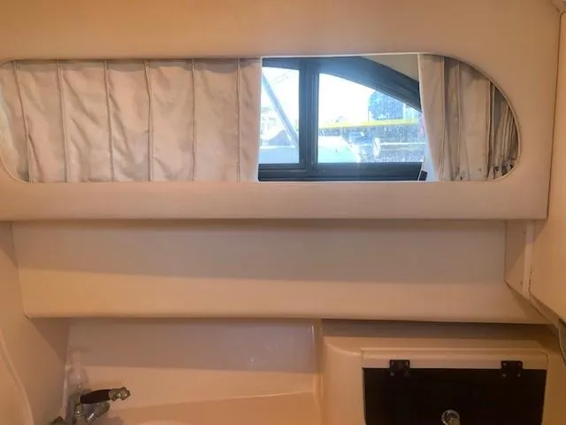 Slide: The Image of Interior view of 2006 Grady-White Marlin 300 boat cabin with window and curtains. - 16