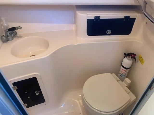 Slide: The Image of 2006 Grady-White Marlin 300 boat bathroom with sink, toilet, and storage compartments. - 17