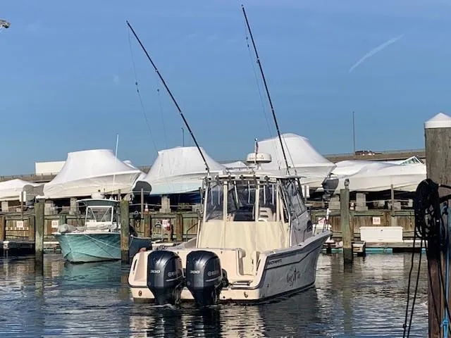 Slide: The Image of 2006 Grady-White Marlin 300 boat docked with twin engines, clear sky background. - 2