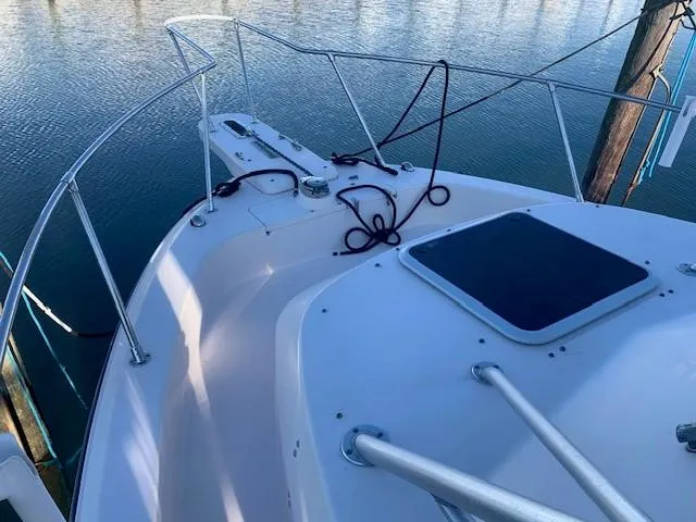 Slide: The Image of 2006 Grady-White Marlin 300 boat deck with railing and ropes, docked on calm water. - 4