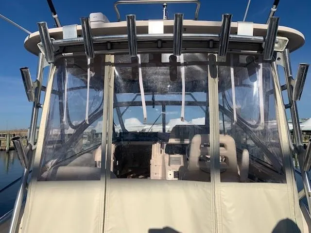 Slide: The Image of 2006 Grady-White Marlin 300 boat with clear enclosure and rod holders, docked at marina. - 6