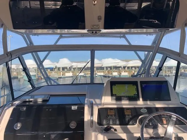 Slide: The Image of 2006 Grady-White Marlin 300 boat cockpit with navigation screens and marina view. - 7