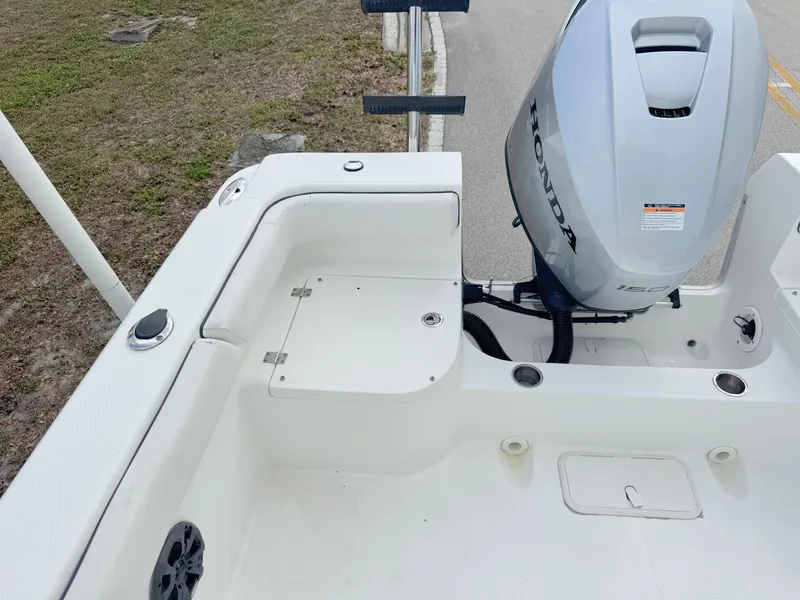 Slide: The Image of 2016 Clearwater 2200 WI Center Console boat with Honda outboard motor, docked near grassy area. - 21