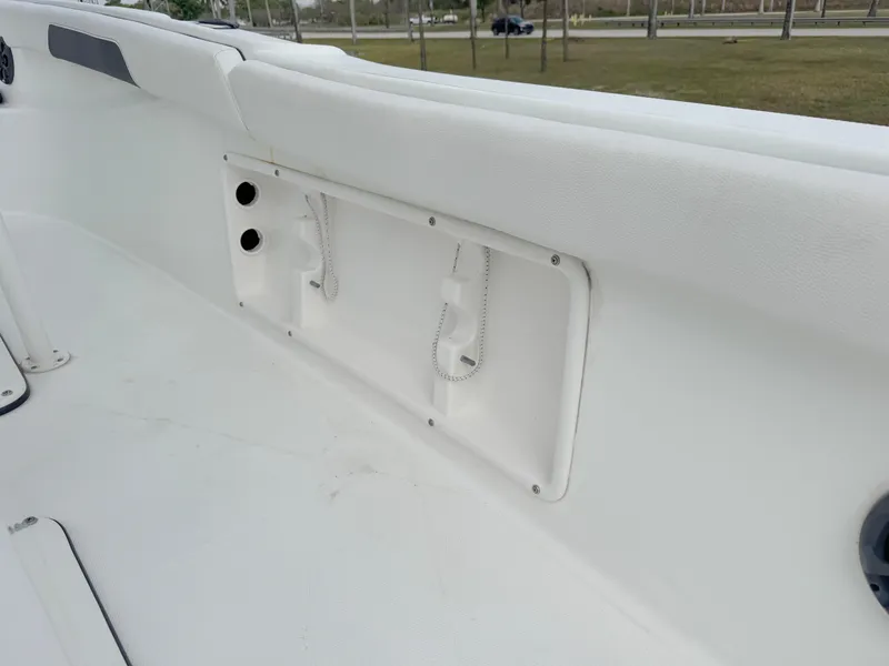 Slide: The Image of 2016 Clearwater 2200 WI Center Console boat interior detail, featuring white seating and storage. - 27