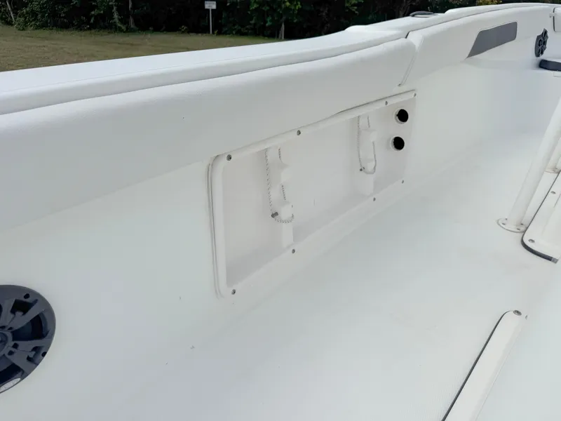 Slide: The Image of 2016 Clearwater 2200 WI Center Console boat interior, featuring white seating and storage compartments. - 28