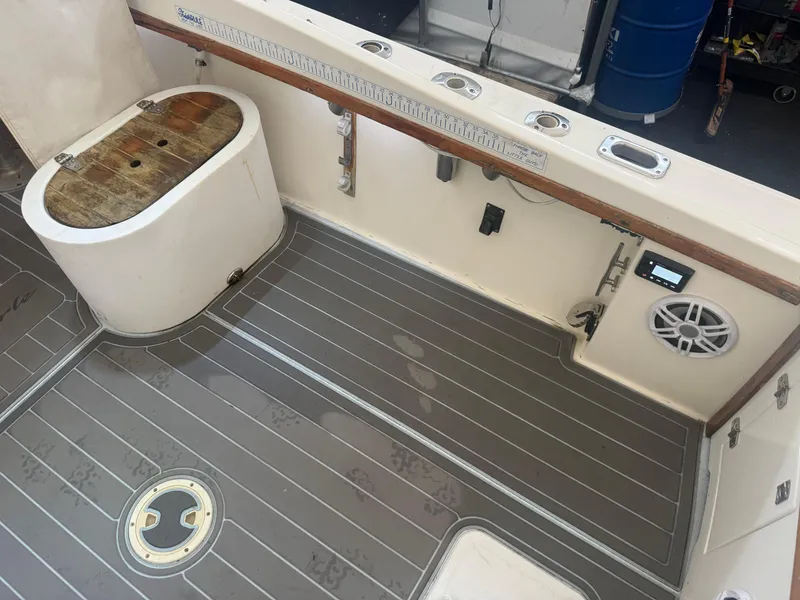 Slide: The Image of 1990 Albemarle 247 Express boat deck with storage, rod holders, and speaker system. - 12