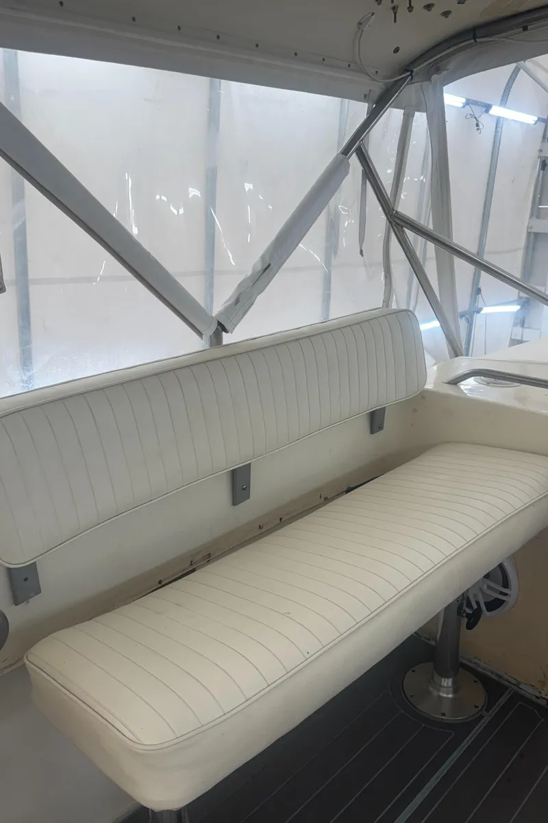 Slide: The Image of 1990 Albemarle 247 Express boat interior with white cushioned seating and metal frame. - 19