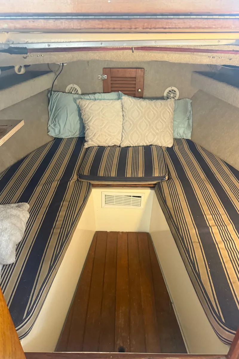 Slide: The Image of 1990 Albemarle 247 Express cabin interior with striped cushions and pillows. - 22