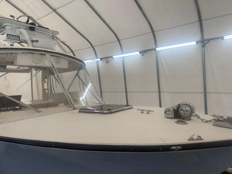 Slide: The Image of 1990 Albemarle 247 Express boat in storage, showcasing deck and cabin details. - 7