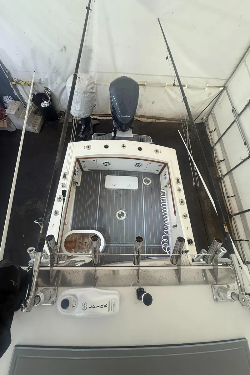 Slide: The Image of 1990 Albemarle 247 Express boat deck with fishing rods and motor, viewed from above. - 8