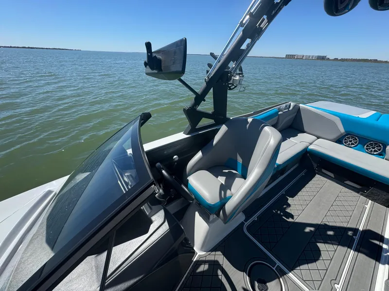 Slide: The Image of 2018 Axis T23 boat interior with steering wheel, seating, and lake view. - 11