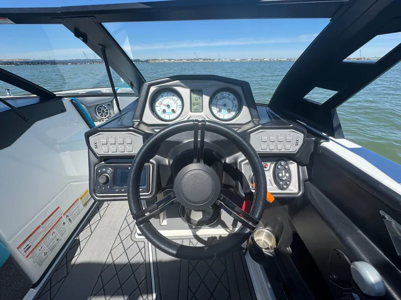 Slide: The Image of Steering console of a 2018 Axis T23 boat with gauges and controls, overlooking water. - 14