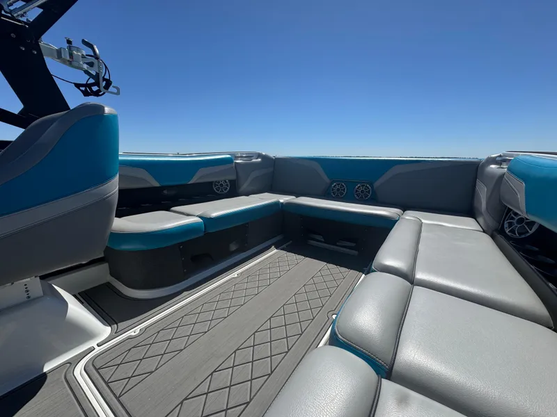 Slide: The Image of Interior of 2018 Axis T23 boat with gray and blue seating under clear sky. - 17