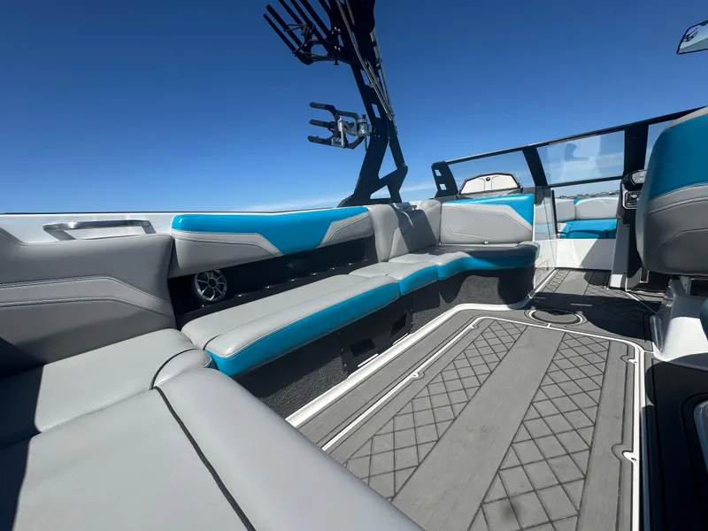 Slide: The Image of 2018 Axis T23 boat interior with blue and gray seating under clear blue sky. - 20
