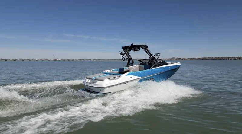 Slide: The Image of 2018 Axis T23 boat cruising on a calm lake under a clear blue sky. - 33
