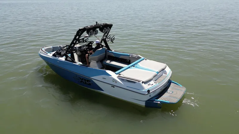 Slide: The Image of 2018 Axis T23 boat on calm water, featuring sleek design and wakeboard tower. - 6