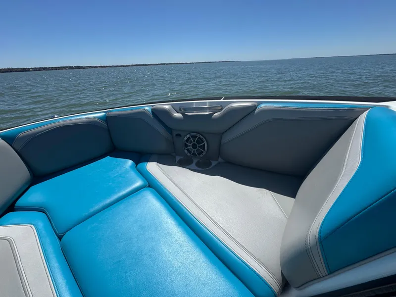 Slide: The Image of 2018 Axis T23 boat interior with blue and gray seating on a sunny day. - 9