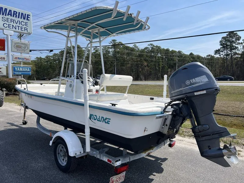 Slide: The Image of 2004 Sundance F17 boat with Yamaha outboard motor on trailer, parked near marine service center. - 3